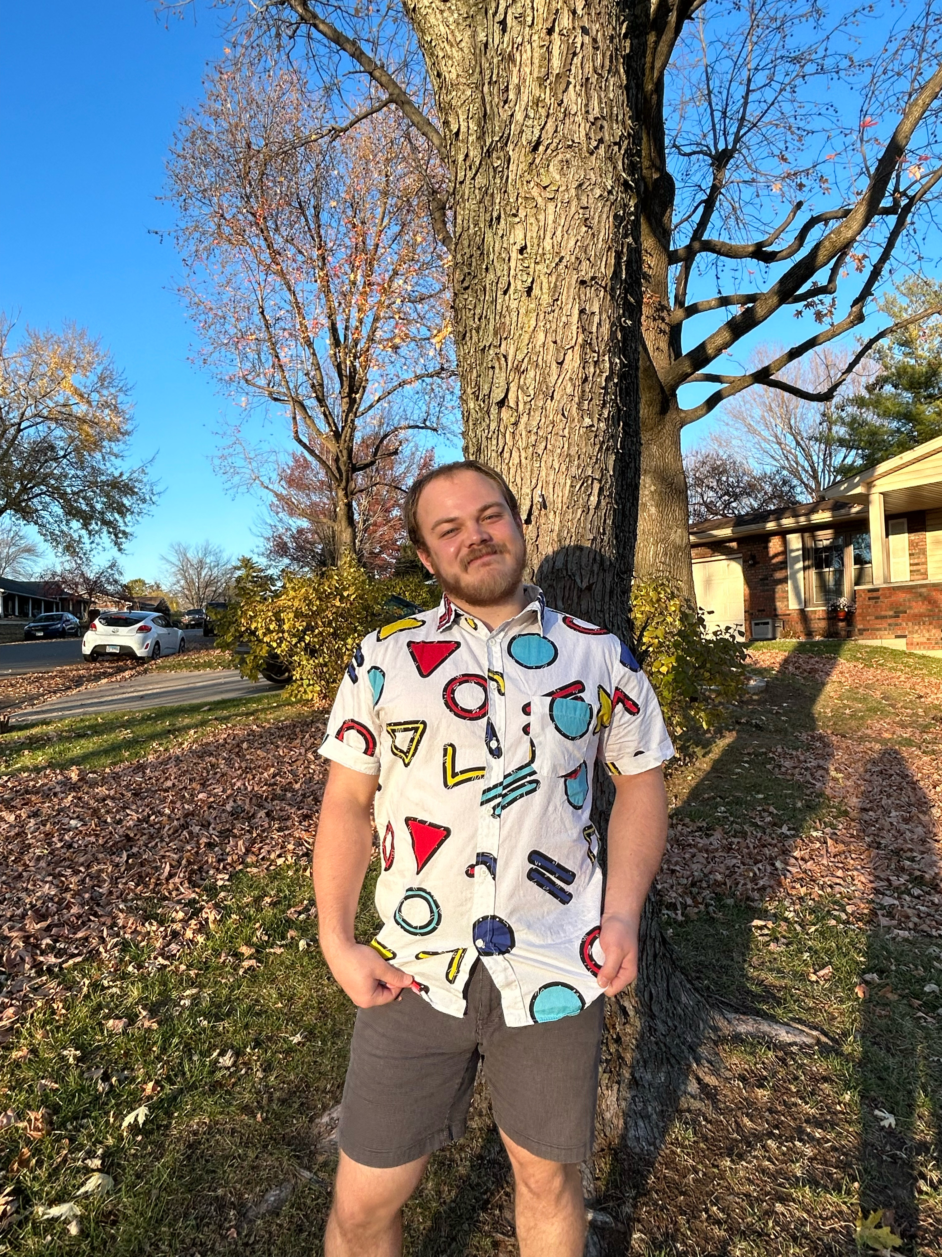 A picture of John Samson showing off a shirt from a compnay he worked with